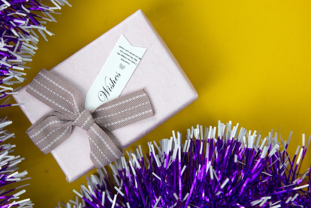 a gift wrapped in pink paper with a bow