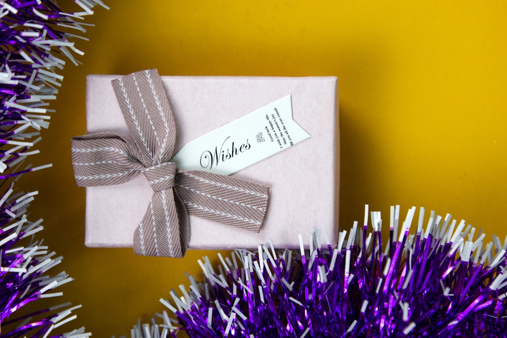 a gift wrapped in pink paper with a ribbon