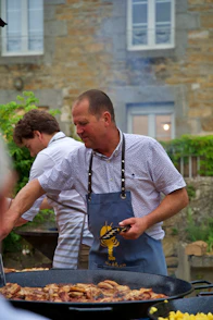 a man in an apron cooking food on a grill