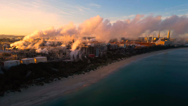 Industrial plant emitting clean air with visible mist and fresh surroundings at sunrise.