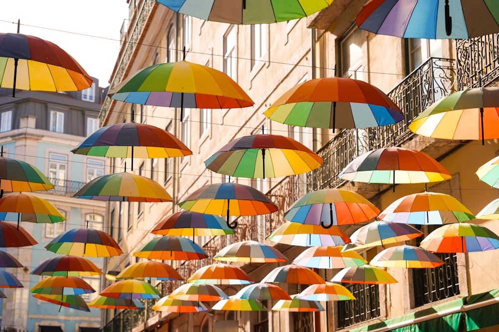Eine Gruppe von bunten Regenschirmen, die an einem Gebäude hängen