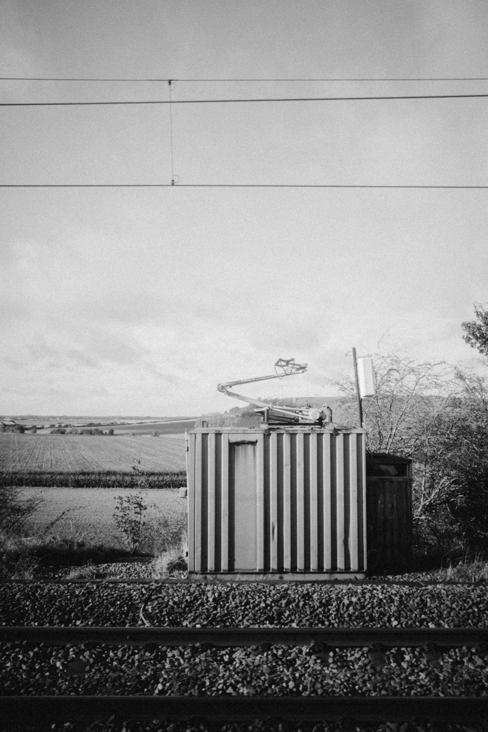 Ein Schwarz-Weiß-Foto einer Kiste, die auf Bahngleisen sitzt