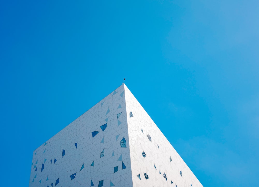 a tall white building with a blue sky in the background