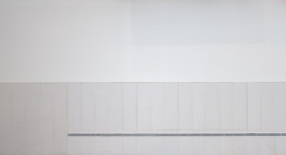 a white room with a bench and a white wall