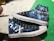 A pair of custom-painted high-top sneakers featuring artwork themed around a music band. One shoe displays a grim reaper figure and the band's name with the word 'Nightmare'. The other shoe showcases the letters 'A7X' in a bold style. The background combines dark and mystical elements with shades of blue and white to create a celestial effect.
