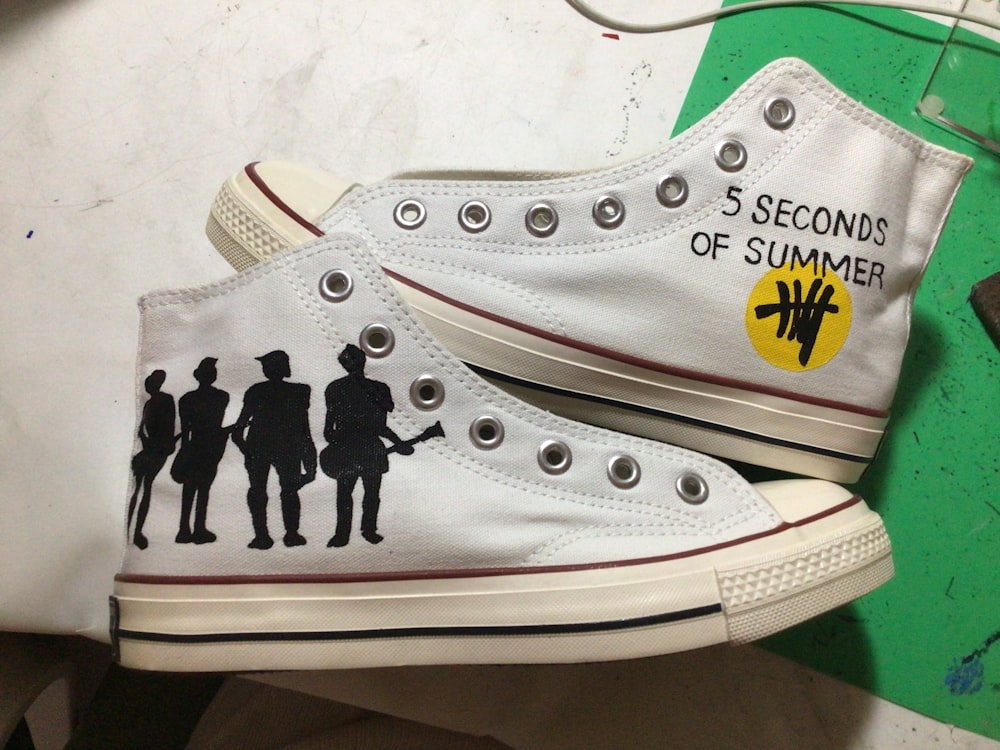 a pair of shoes with the silhouettes of people painted on them