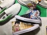 Custom-painted sneakers featuring vibrant anime character designs. The shoes have detailed and colorful illustrations, including elements like waves and various shades, with the artwork skillfully applied on the canvas surface.