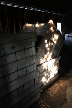 A rustic barn auction setting with neatly stacked farm equipment under soft afternoon light.
