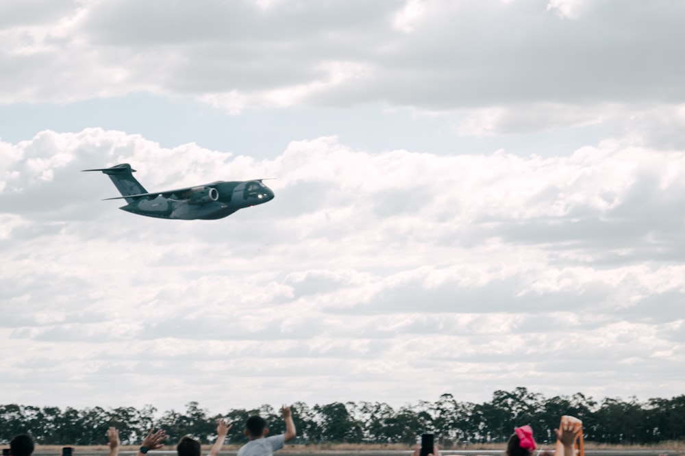 a group of people watching a plane fly overhead