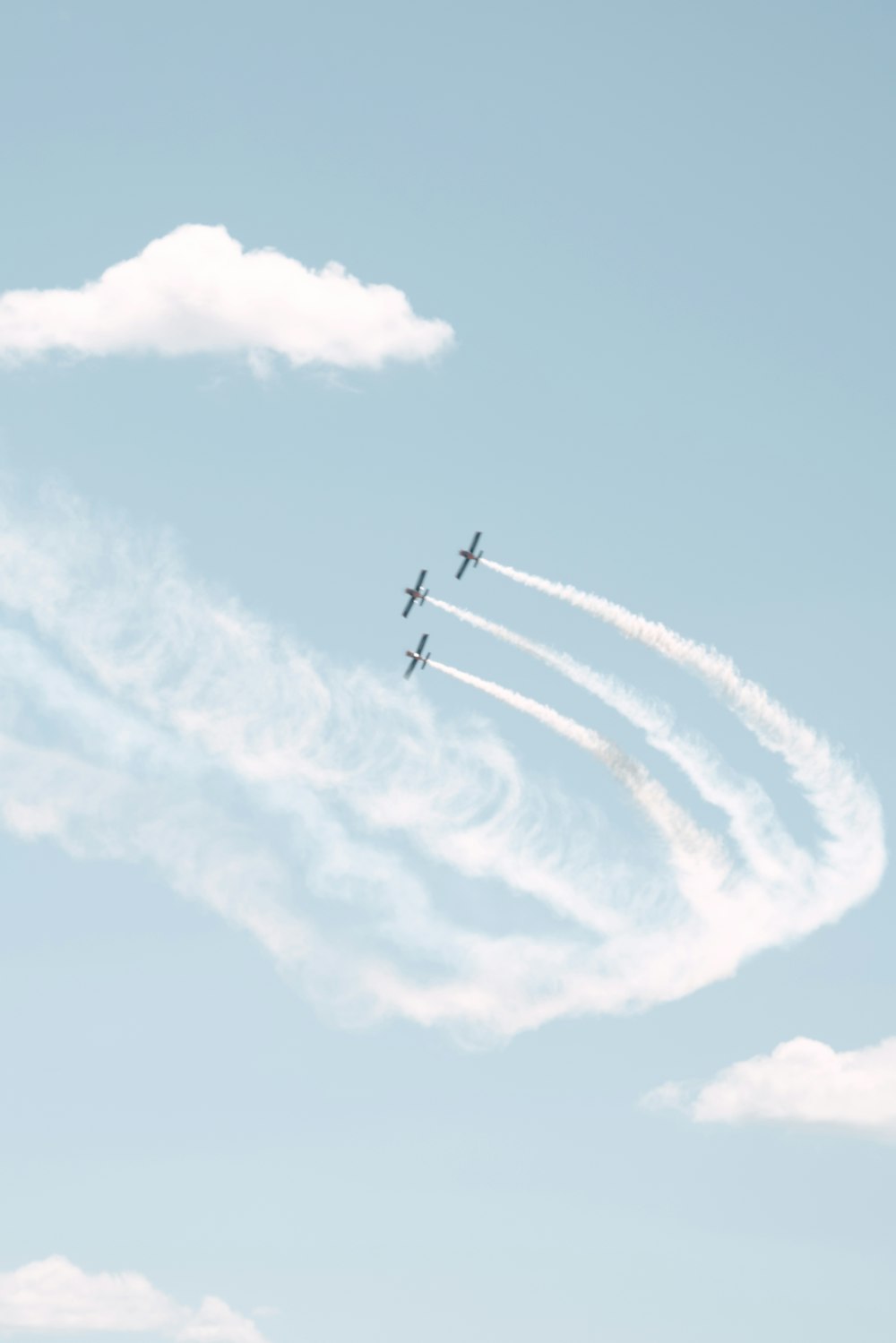 a group of airplanes flying through a blue sky