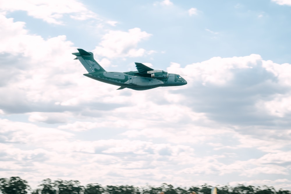 a small airplane flying through a cloudy blue sky