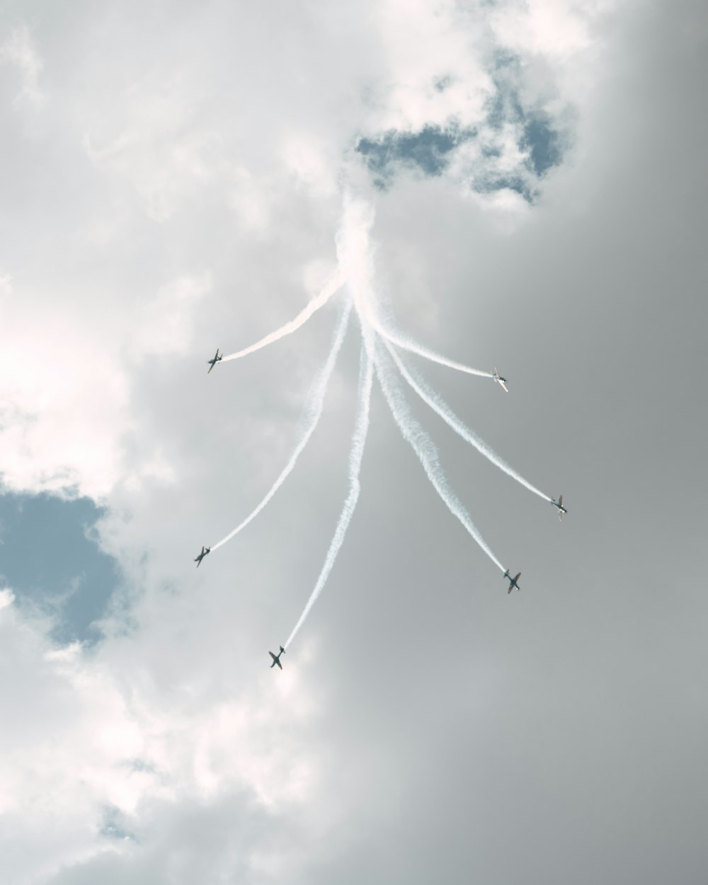 a group of airplanes flying through a cloudy sky