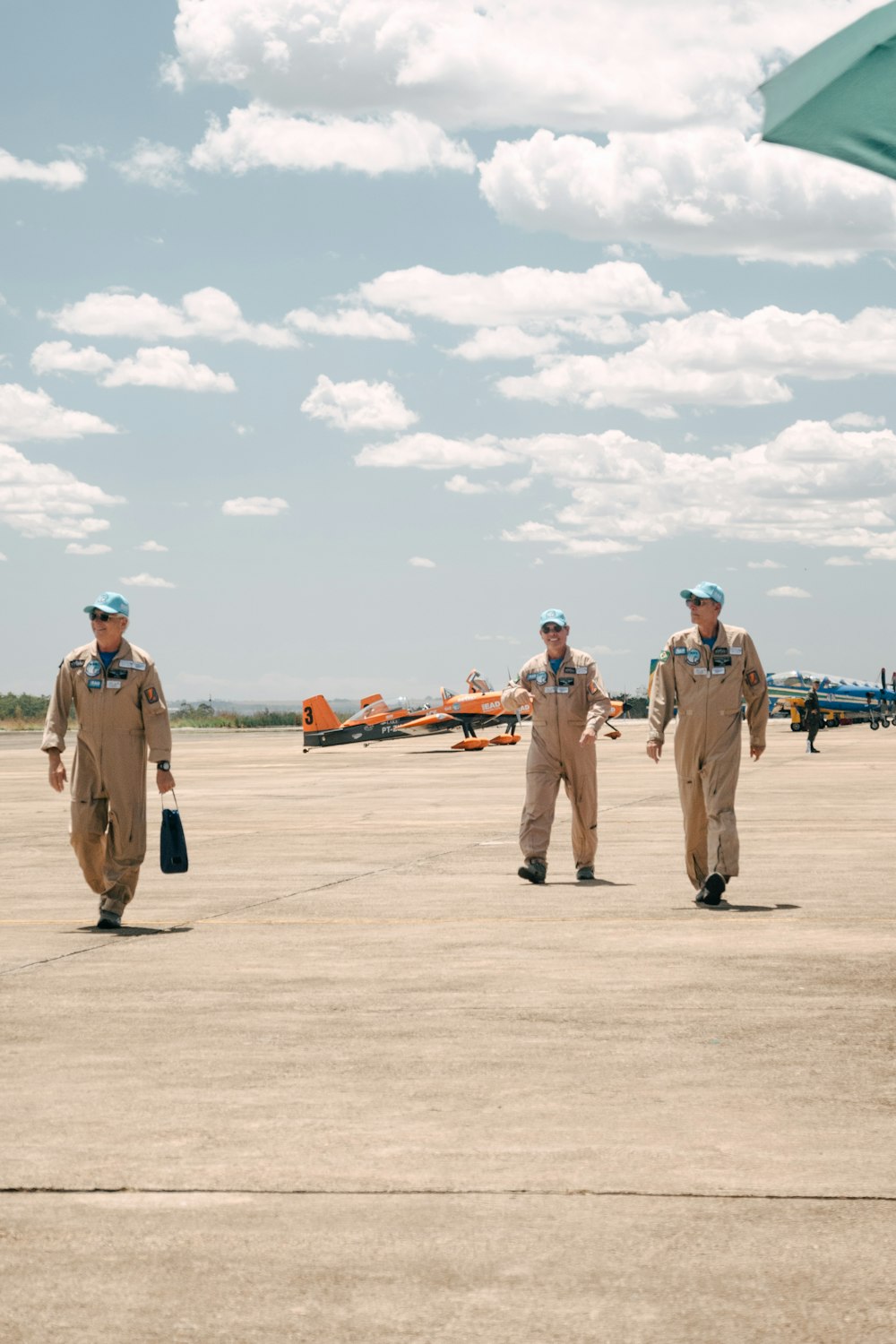 a group of men standing on top of an airport tarmac