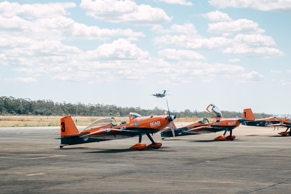 um grupo de pequenos aviões sentados em cima de uma pista do aeroporto