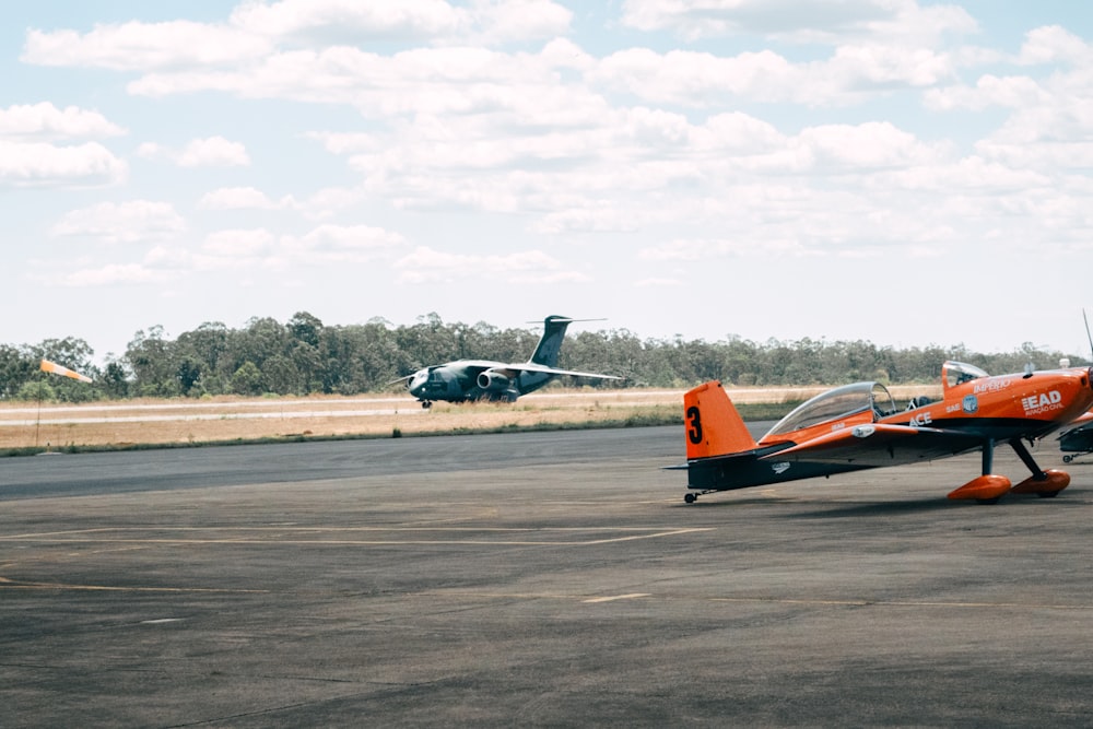 a small plane is on the runway with another plane in the background