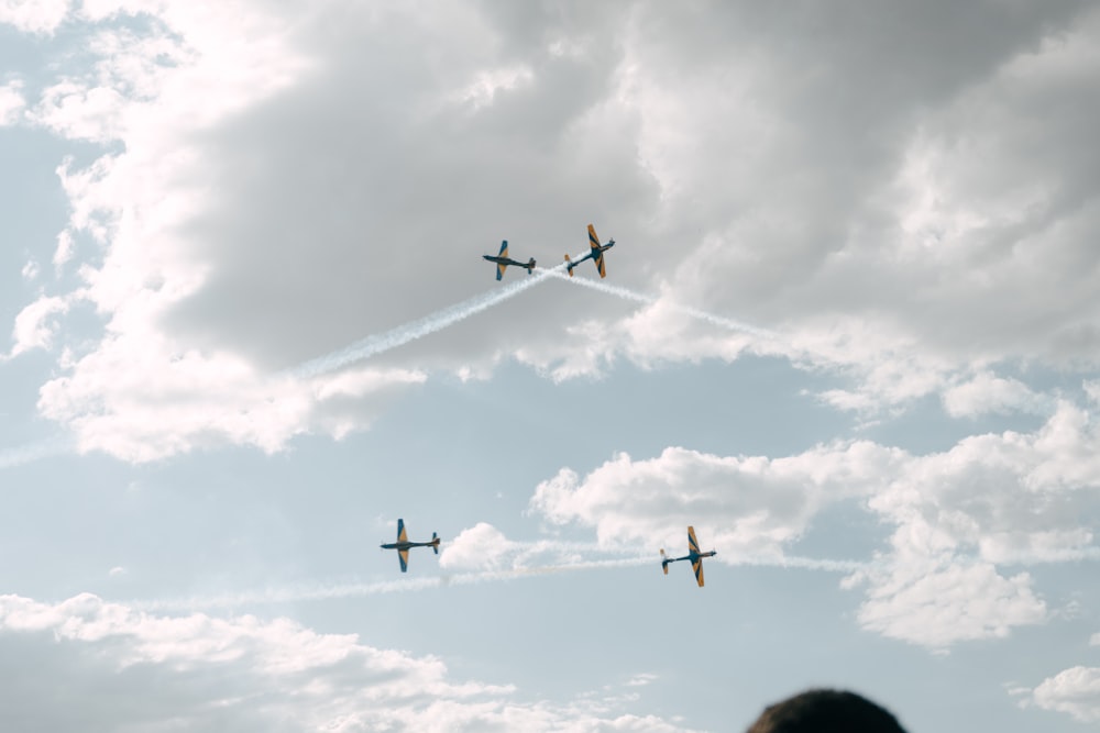 a group of airplanes flying through a cloudy sky