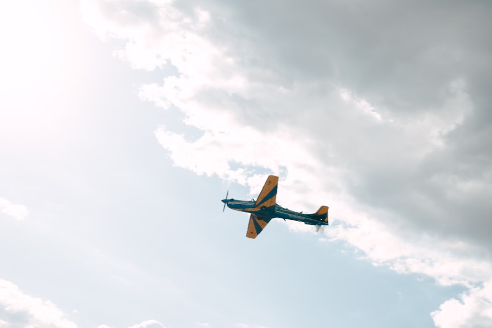 a small airplane flying through a cloudy sky