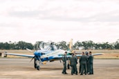 A group of diverse aviation ground staff smiling together near an airplane.