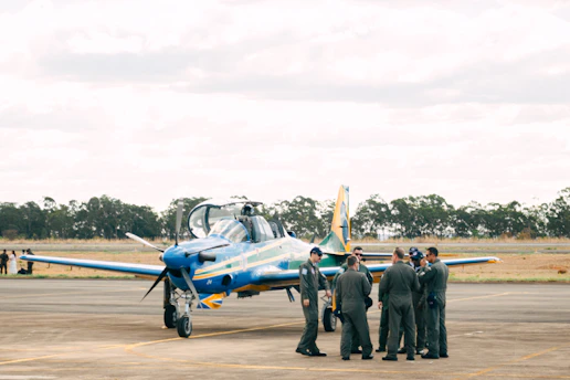 A group of ex-air force members gathered in uniform, sharing stories under a clear blue sky.