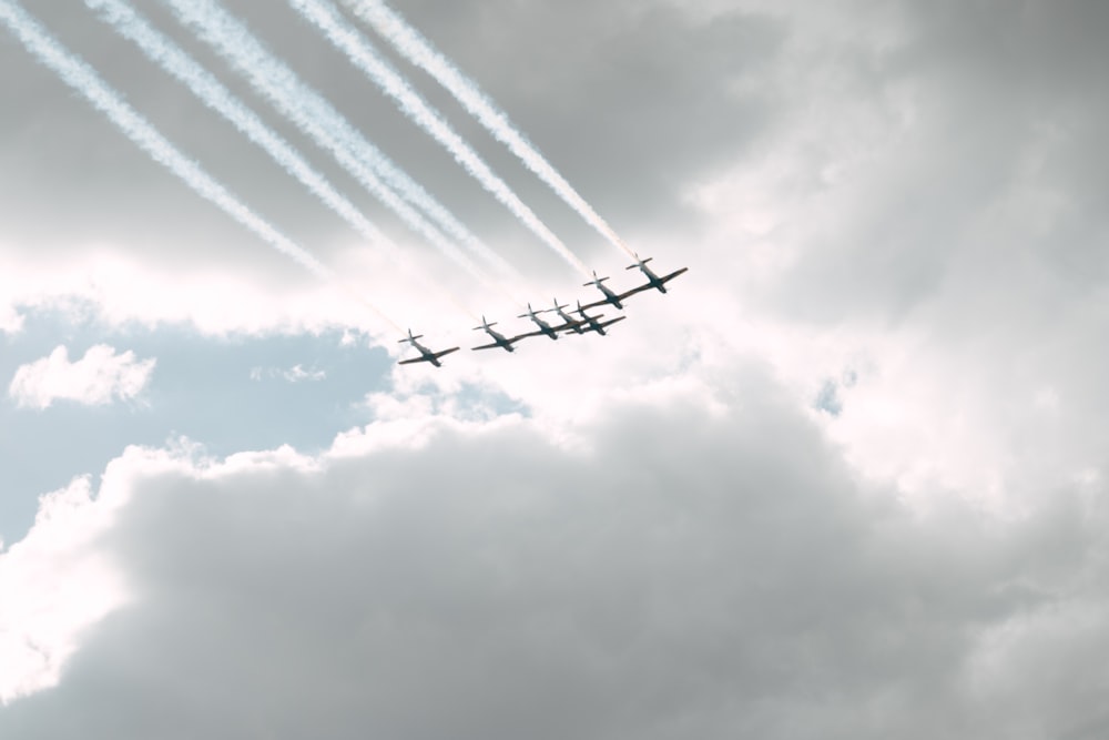 a group of airplanes flying through a cloudy sky