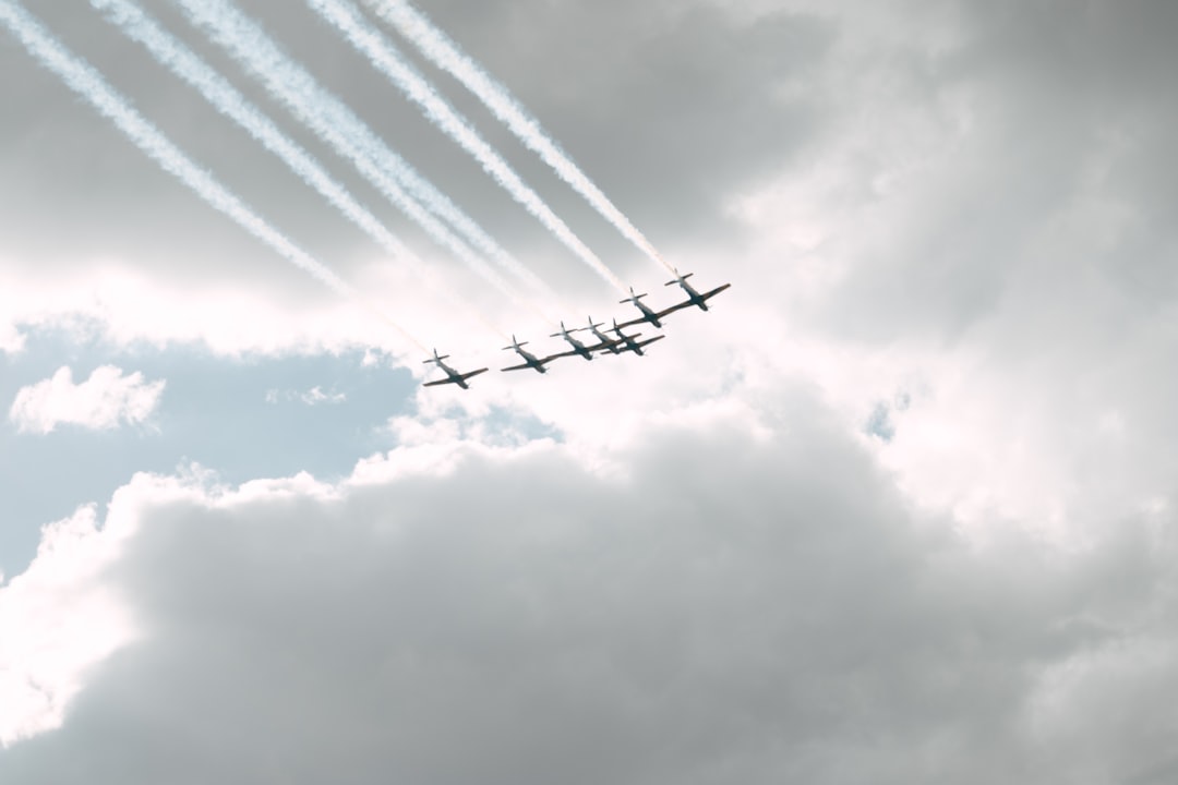 a group of airplanes flying through a cloudy sky,