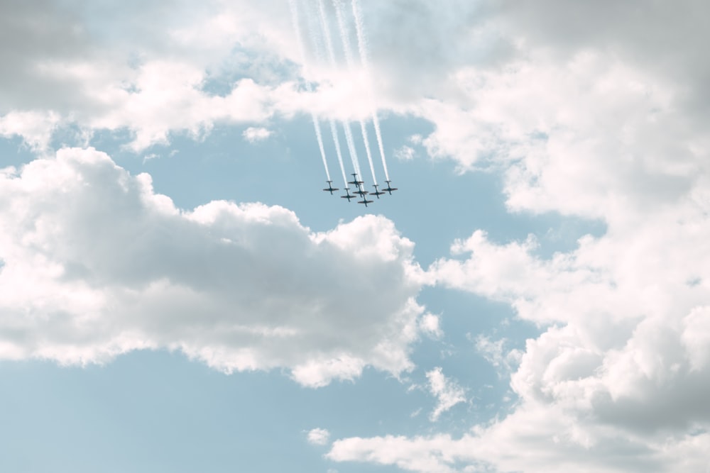 a group of airplanes flying through a cloudy sky