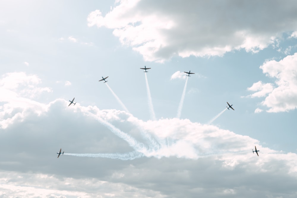 a group of airplanes flying through a cloudy sky