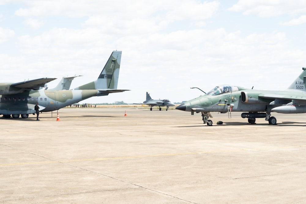 a group of fighter jets sitting on top of an airport tarmac