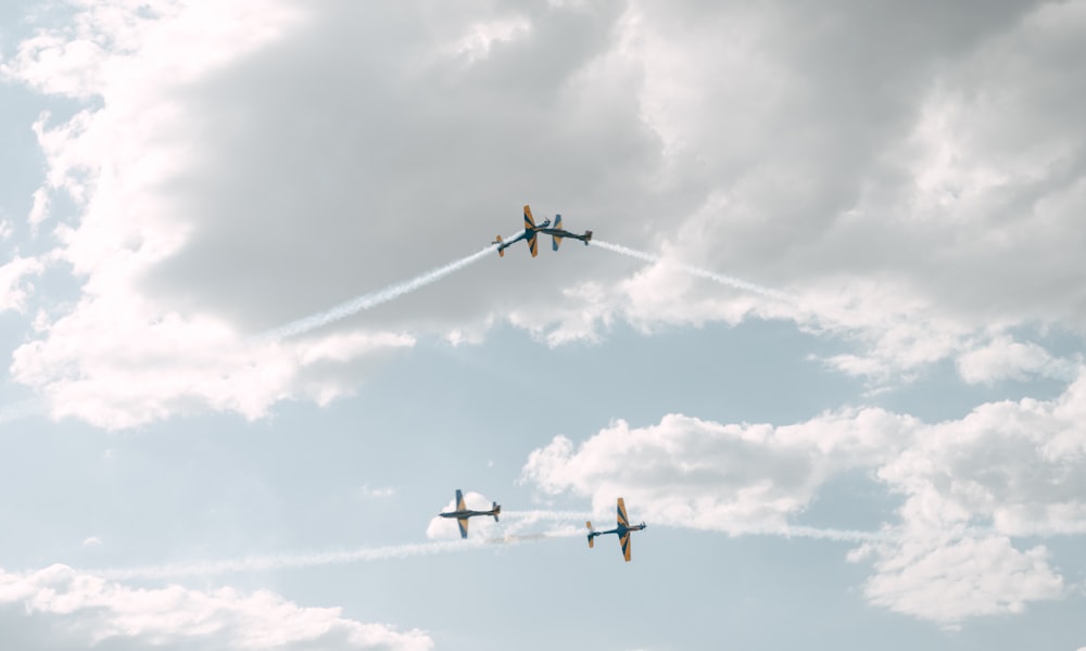 a group of airplanes flying through a cloudy sky