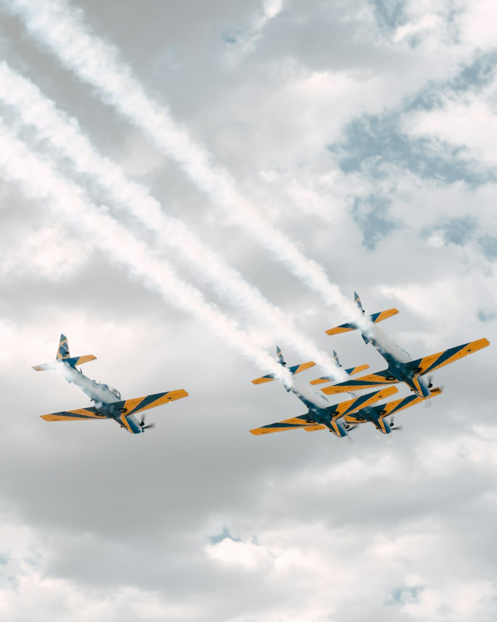 a group of airplanes flying through a cloudy sky