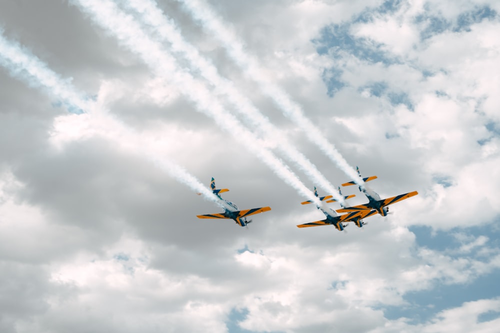 a group of airplanes flying through a cloudy sky