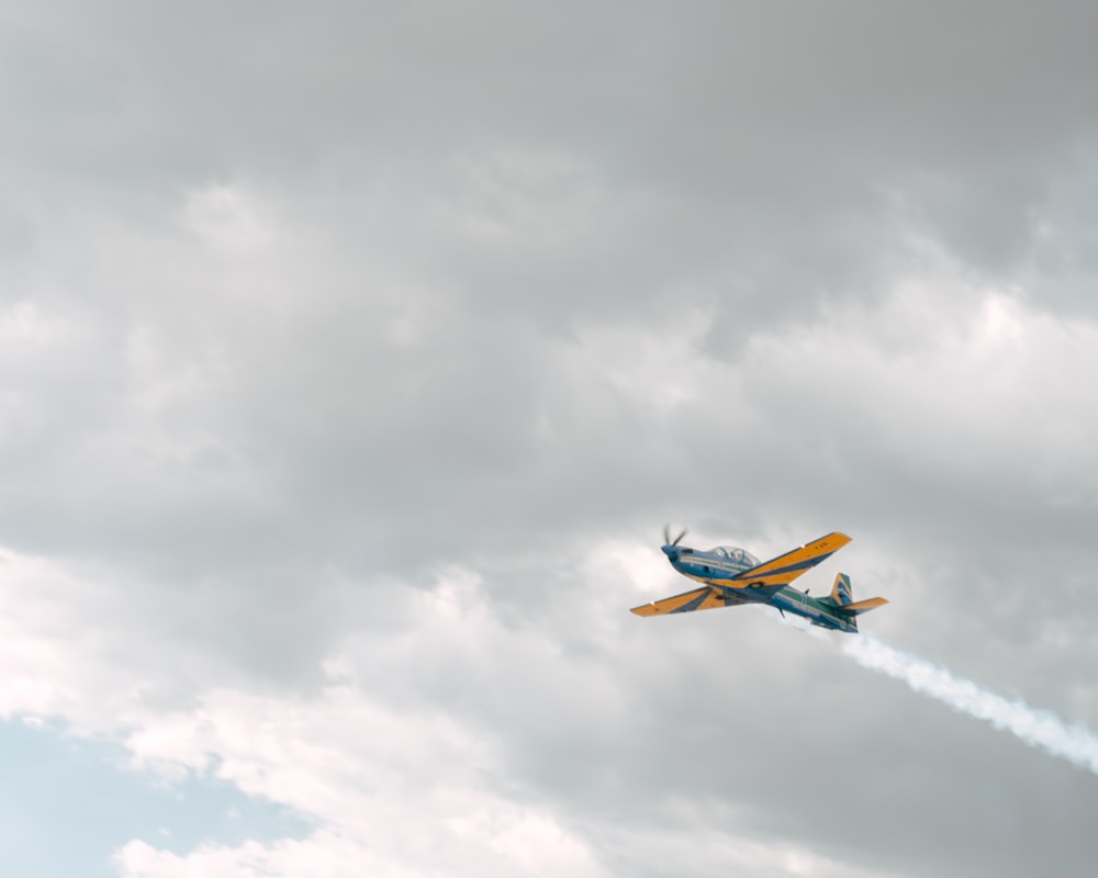 a small plane flying through a cloudy sky