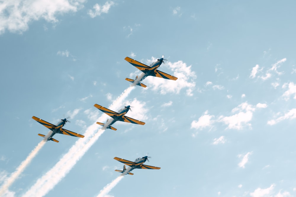 a group of planes flying through a blue sky
