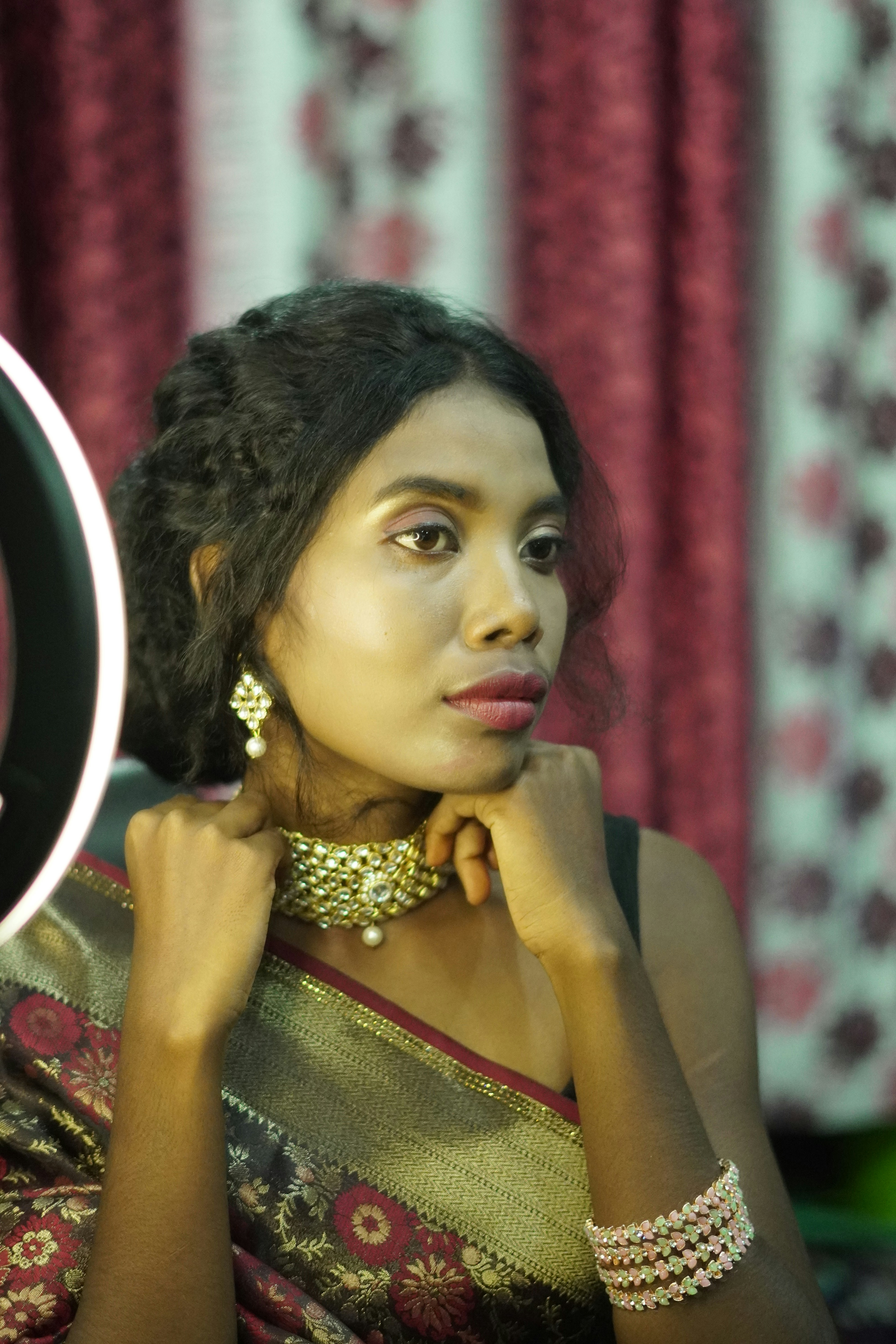 Eine Frau in einem Sari schaut in einen Spiegel