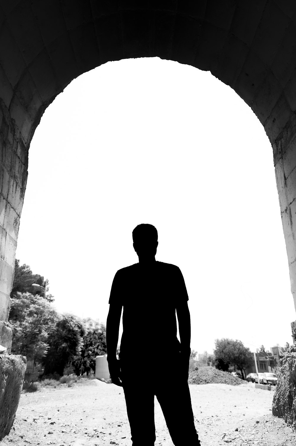 a silhouette of a man standing in a tunnel