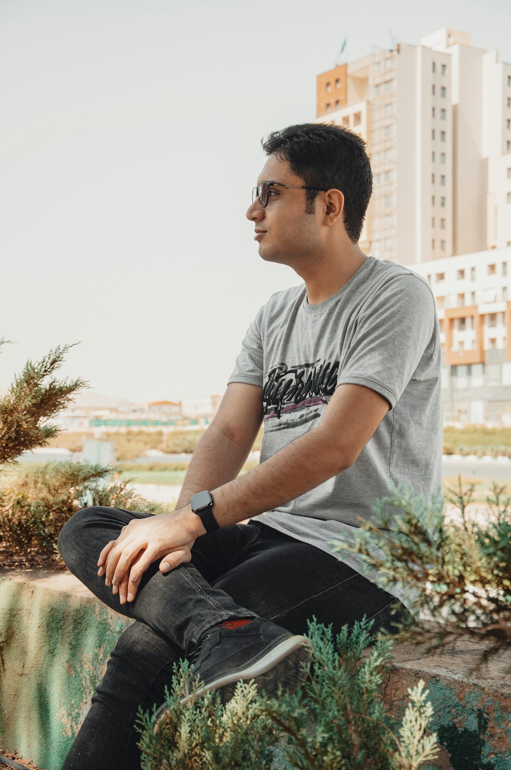 a man sitting on top of a cement wall