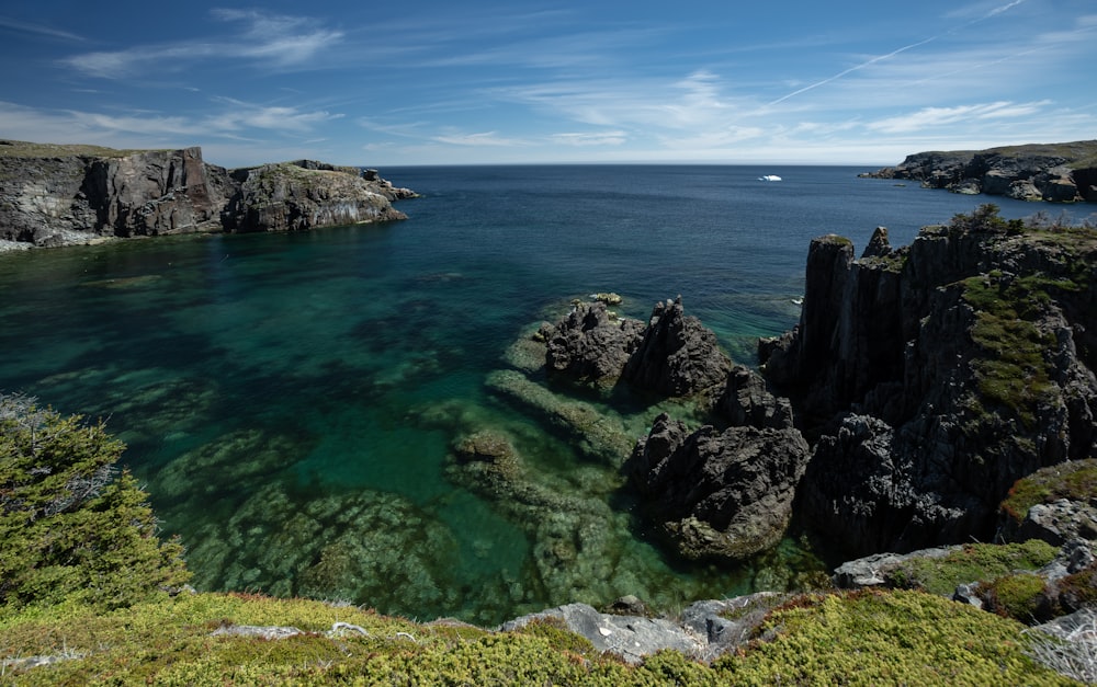 a body of water surrounded by rocks and grass