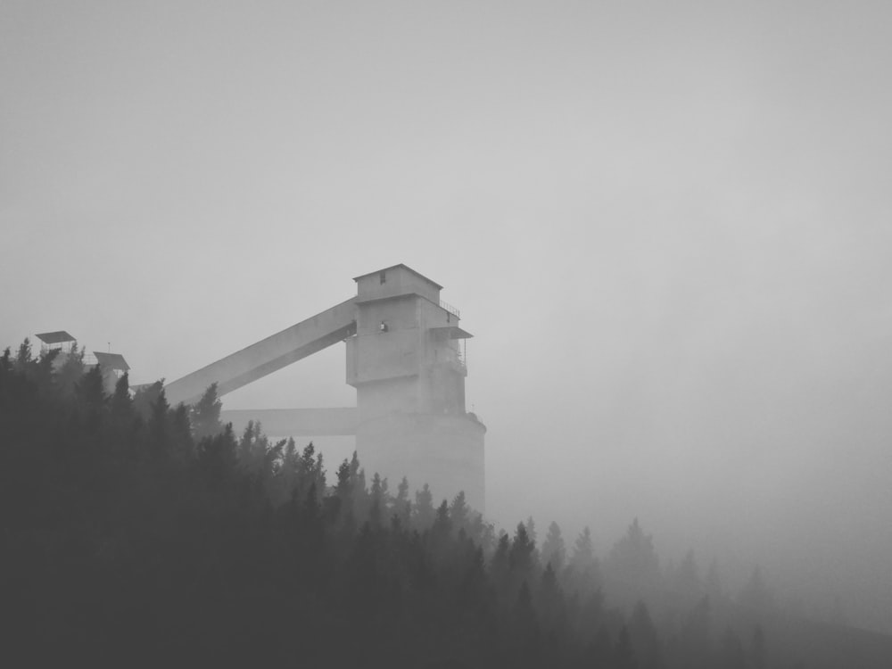 a black and white photo of a clock tower on a foggy day