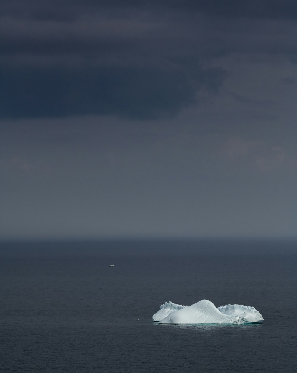 an iceberg floating in the middle of the ocean