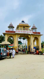 Nearby temple entrance bustling with pilgrims and colorful decorations.