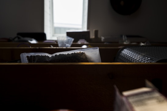 A vibrant sack of fresh ragi millet grains displayed on a rustic wooden table near a window with natural light.