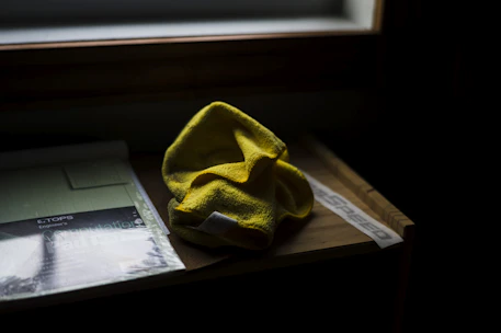 A professional cleaner wiping down a sleek office desk with a microfiber cloth.