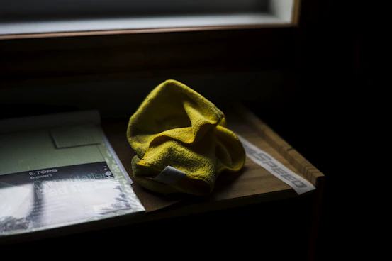 A professional cleaner gently wiping a sleek office desk with a microfiber cloth.