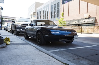 A sleek Irishcorktaxi car waiting outside a busy Cork city street at dusk.