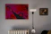 Close-up of a modern art print hanging on a minimalist wall in a cozy living room.