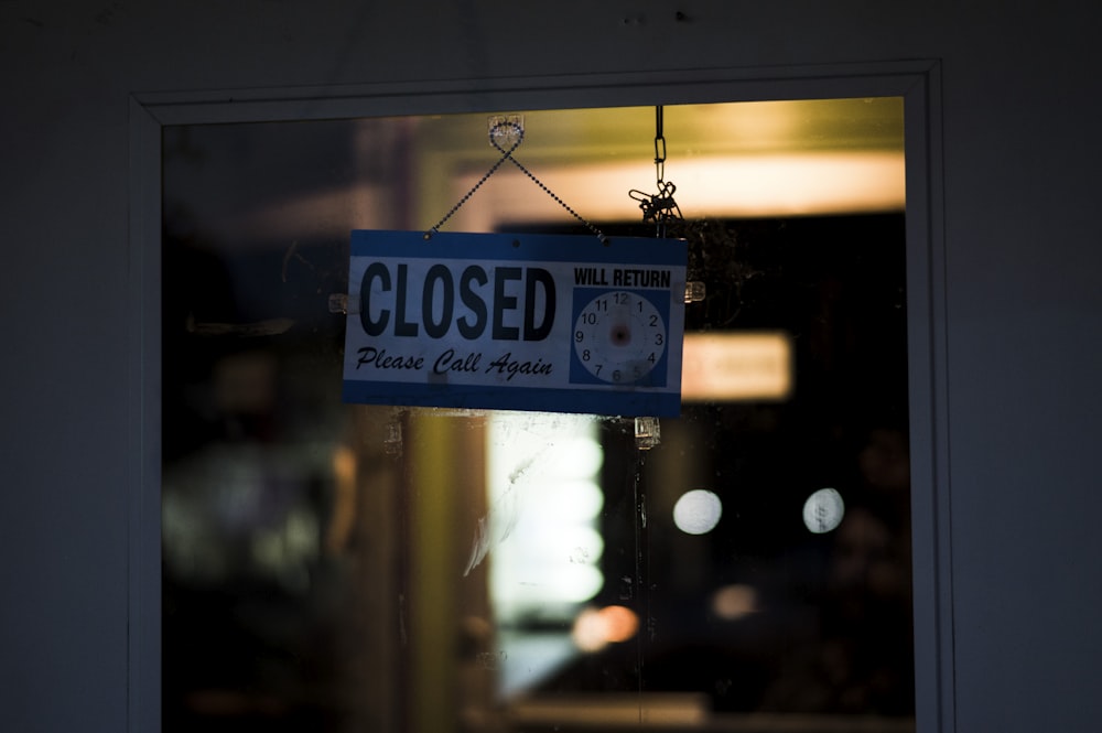 a closed sign hanging from the side of a window