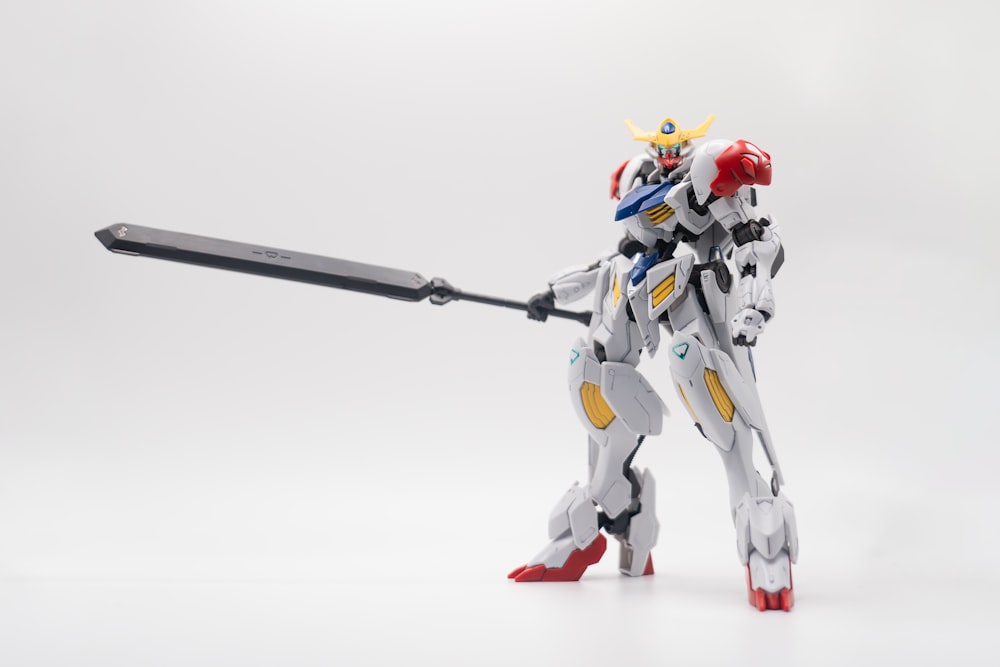 a robot that is holding a sword on a white background