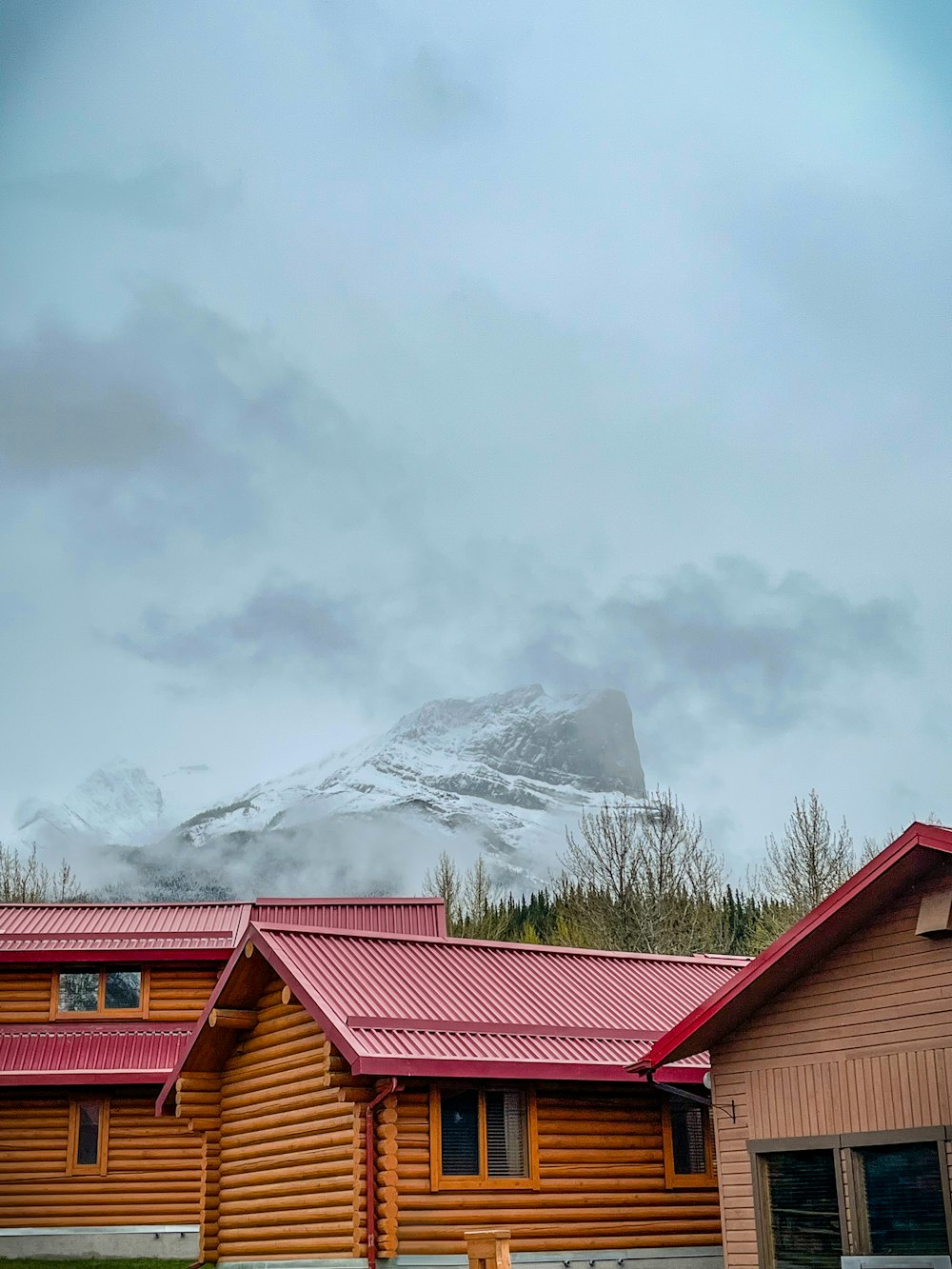 a house with a red roof and a mountain in the background