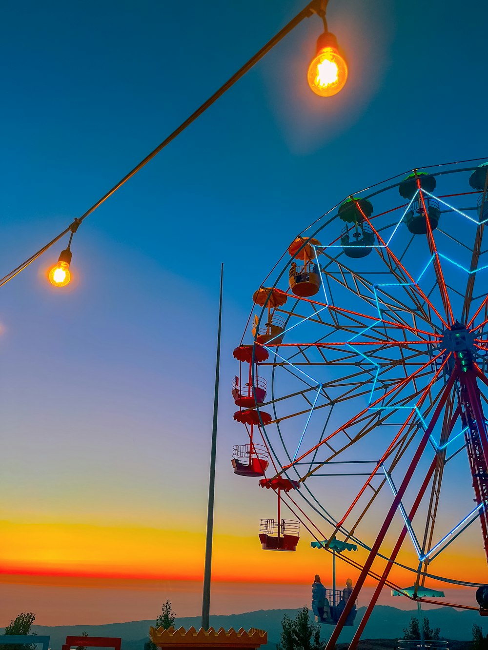 a ferris wheel sitting next to a street light