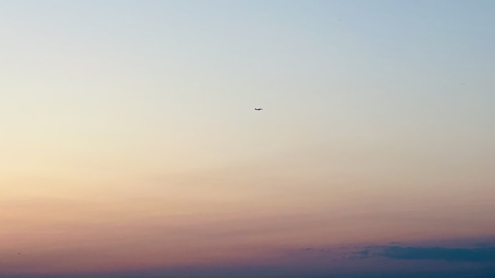 Un avión volando en el cielo al atardecer